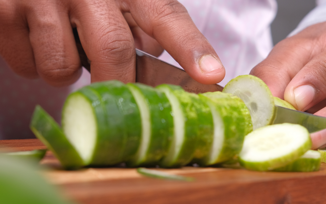 Photo of man's hands chopping a cucumber